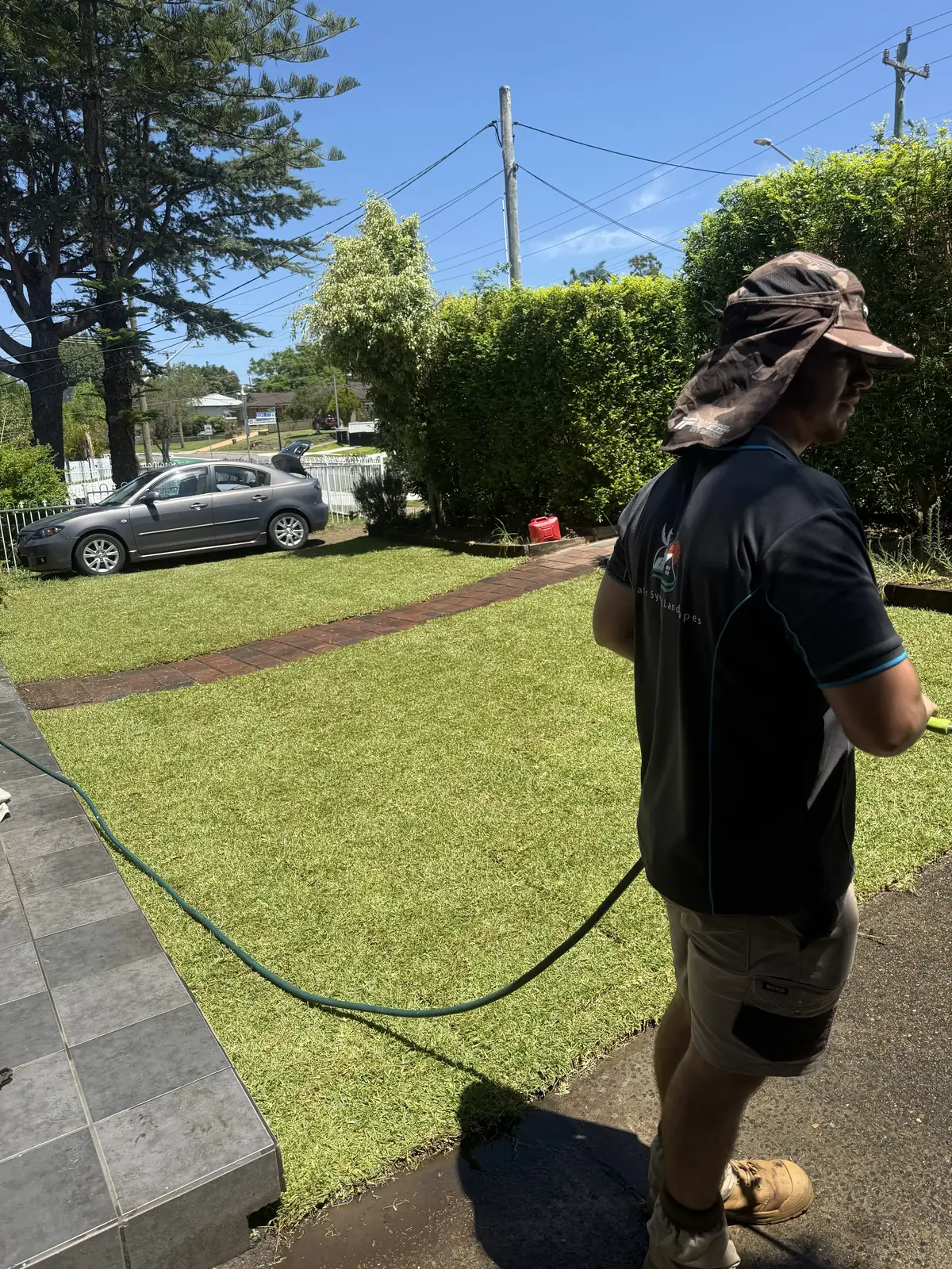 Lawn care in Sydney — watering in a freshly treated lawn after fertilising